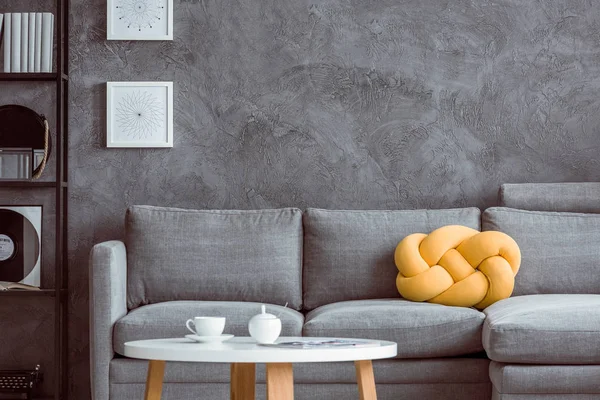 Szara sofa z betonową ścianą — Zdjęcie stockowe