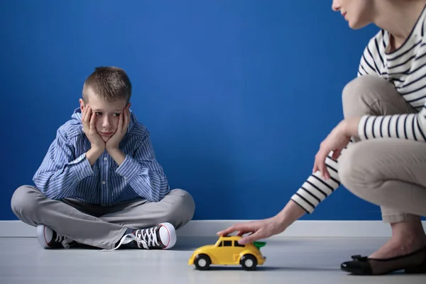 Kind schaut auf gelbes Spielzeug — Stockfoto