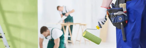 Man with green paint roller — Stock Photo, Image