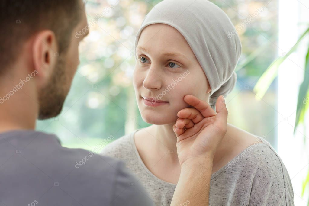 Husband stroking ill wife's face 