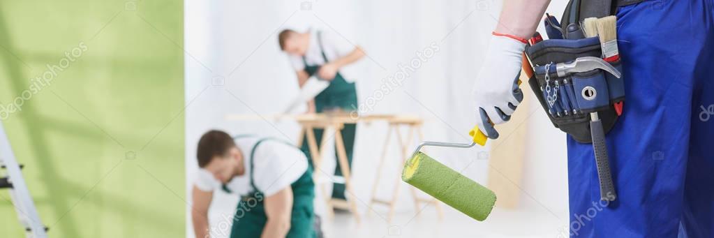 Man with green paint roller