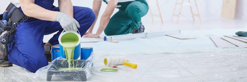 House painter pouring green paint