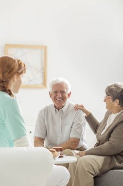 Gülümseyen kıdemli eş yanında oturan