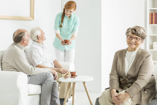 Медсестра даёт чашку кофе.
