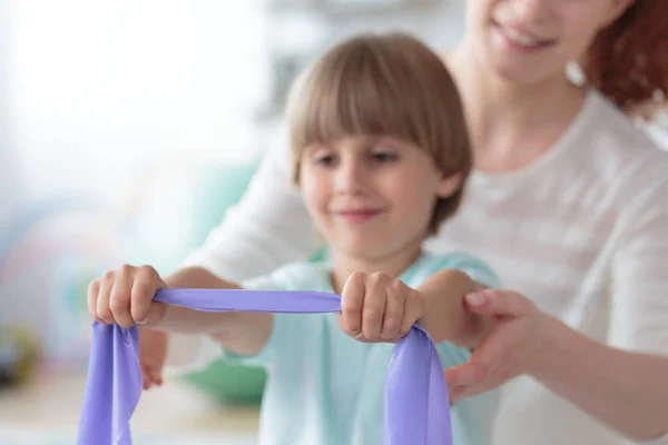 Boy stretching with physiotherapist — Stock Photo, Image