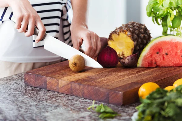 Vrouw op dieet snijden fruit — Stockfoto