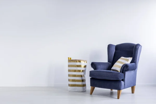 Золотая подушка на синем кресле — стоковое фото