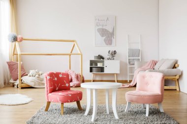 Gri halı üzerinde beyaz sehpa 