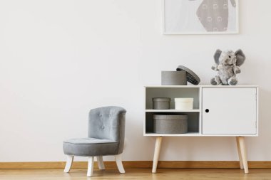 Beyaz raf yanındaki gri sandalye