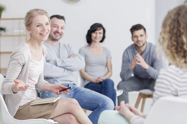 Smiling therapist talking to people — Stock Photo, Image