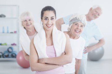 Gülümseyen eğitmen ve yaşlı insanlar