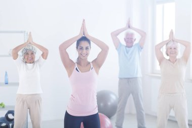 Yaşlı insanlar yoga yaparken poz