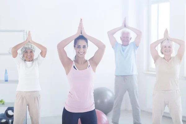 Äldre människor som gör yoga posera — Stockfoto