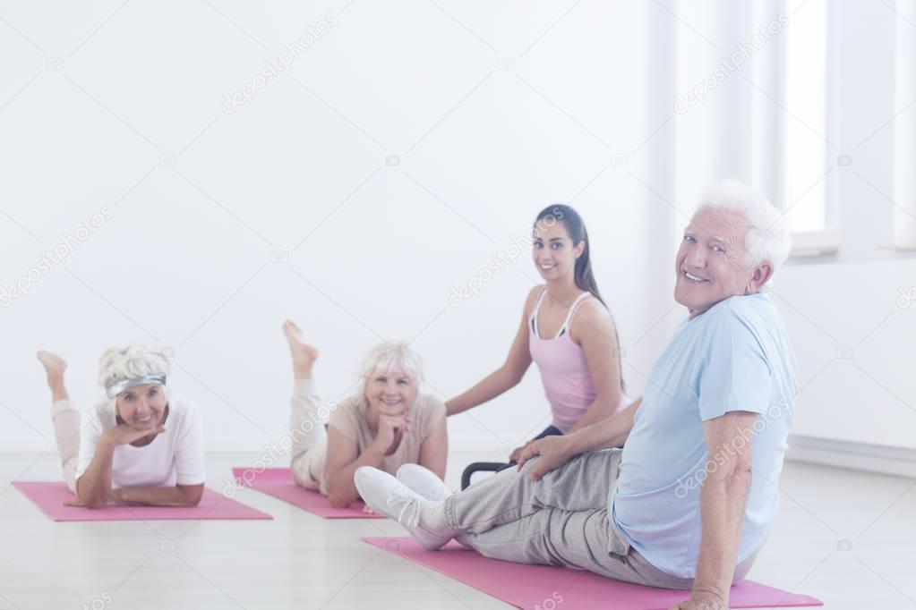 Elderly man relaxing on mat