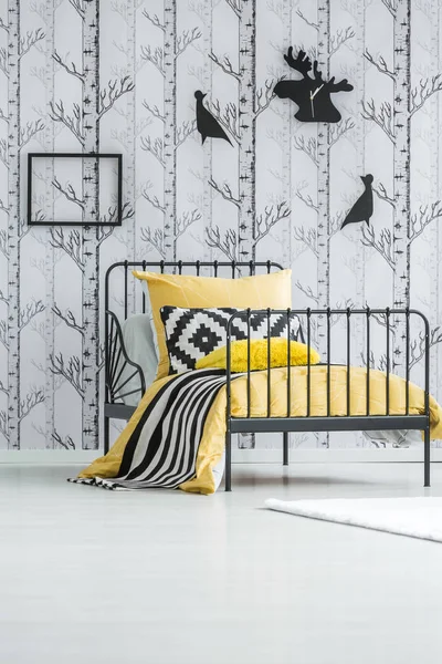 Basit yatak odasında sarı yatak