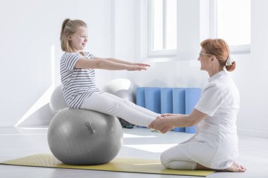 Kız gri topa oturur