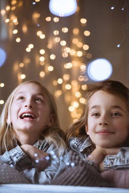 Kız kardeşler pencereden dışarı bakarak