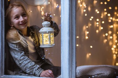 Kız pencereden dışarı bakıyor.