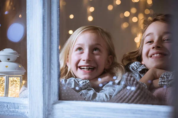 Flickor som tittar ut genom fönstret — Stockfoto