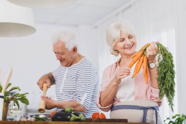Gülümseyen yaşlı kadın tutun havuç