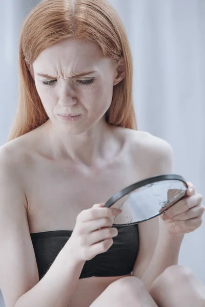 Дівчина дивиться в розбите дзеркало — стокове фото
