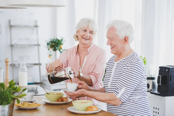 Woman pours coffee into the cup