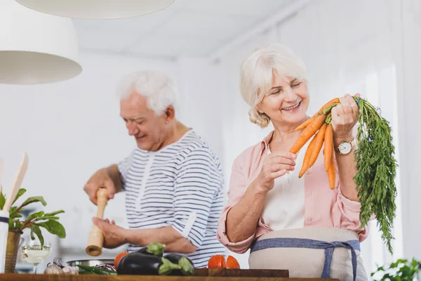 Gülümseyen yaşlı kadın tutun havuç