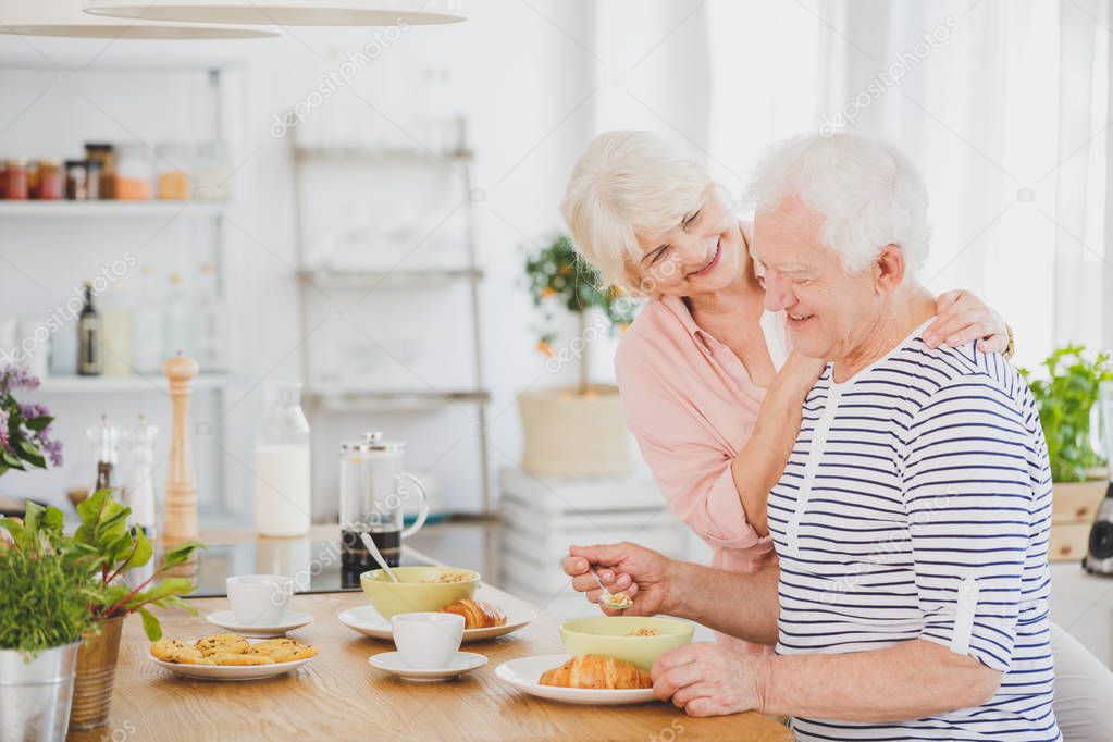 Grandfather is sitting at wooden table