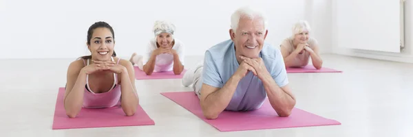 Пожилые люди, растянувшиеся на ковриках для йоги — стоковое фото