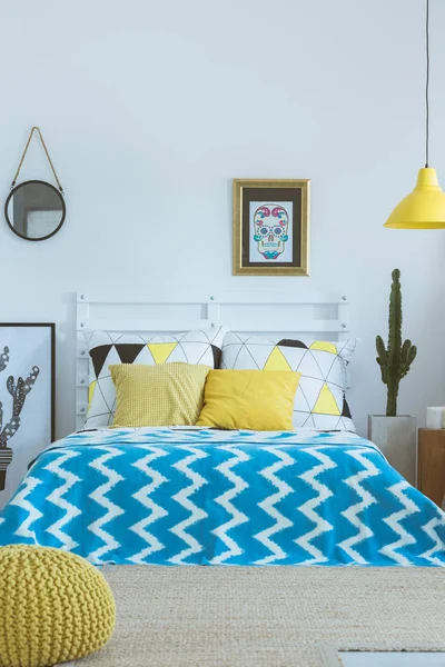 Bed met blauwe gedessineerde coverlet — Stockfoto