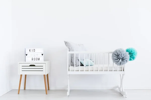 White cradle with pastel pompons — Stock Photo, Image