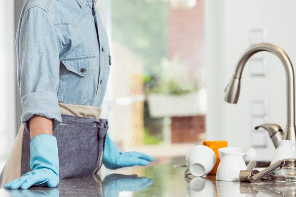 Жінка стоїть біля кухонної мийки — стокове фото