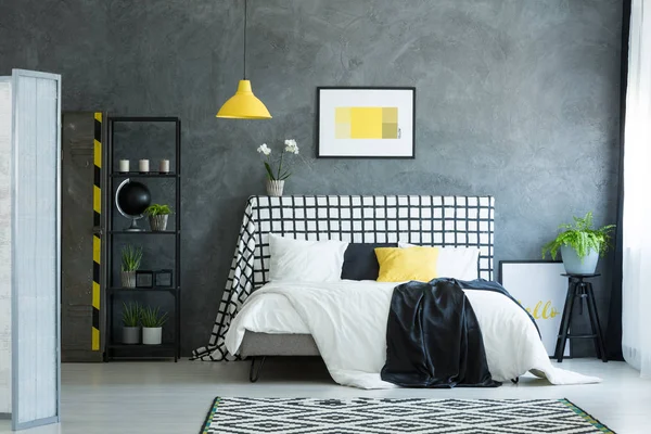 Кровать против темной текстурированной стены — стоковое фото