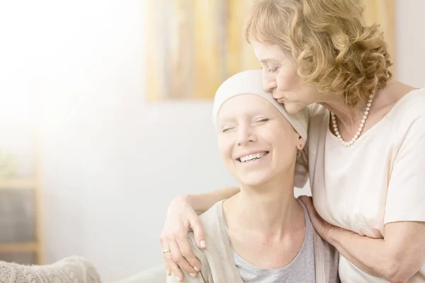 Femme embrassant temple du survivant du cancer — Photo