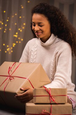 Büyük hediye tutan gülümseyen kadın