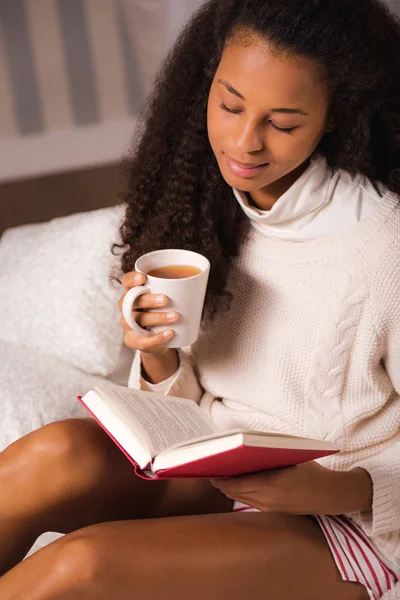 Девушка пьет чай и читает — стоковое фото
