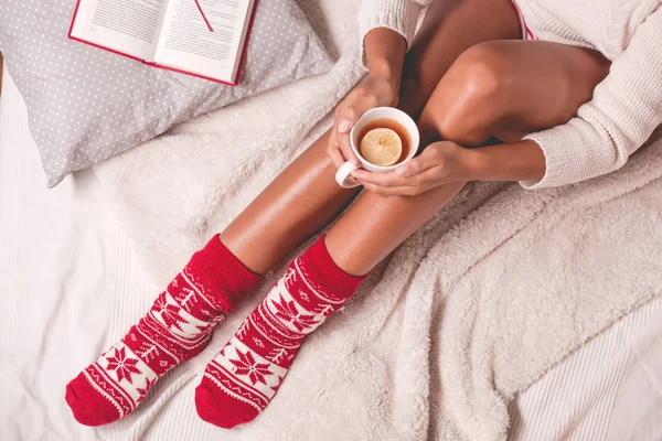 Mujer en calcetines de Navidad sosteniendo taza — Foto de Stock