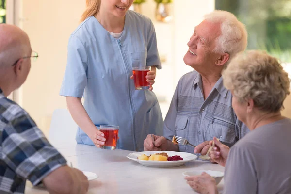Pielęgniarka daje sok do seniorów — Zdjęcie stockowe