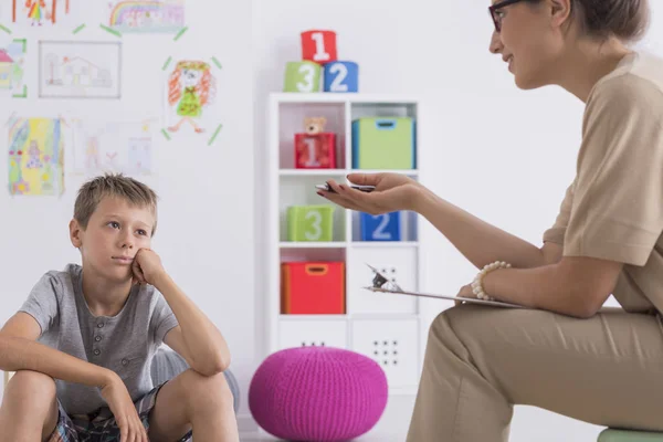 Psikoterapist ile toplantı sırasında düşünceli çocuk — Stok fotoğraf