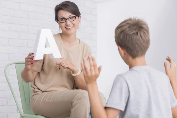 Mooie logopedist helpt jongen — Stockfoto