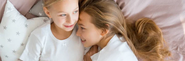 Dos hermanitas tumbadas en la cama —  Fotos de Stock