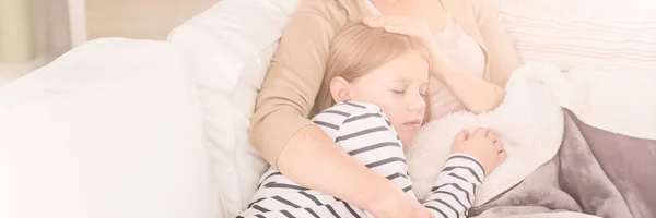 Woman embracing sleeping daughter — Stock Photo, Image