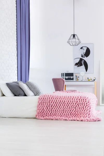 Розовое трикотажное одеяло на кровати — стоковое фото