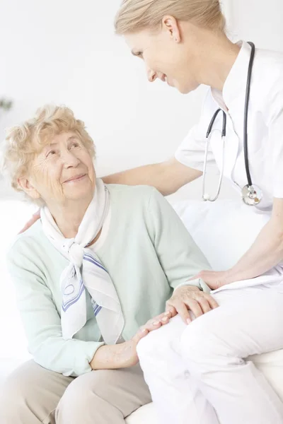 Старшая женщина разговаривает с врачом — стоковое фото