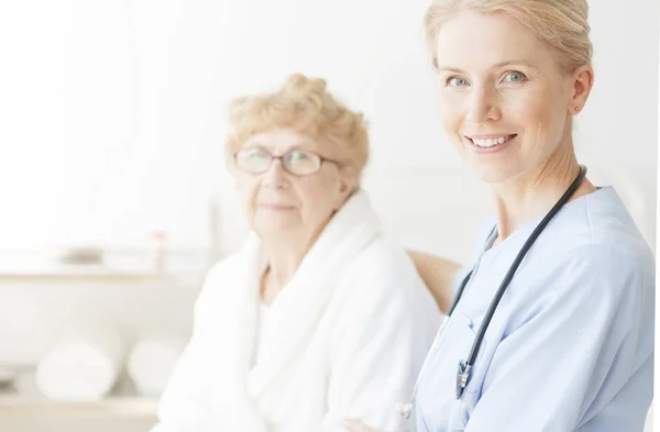 Jeune infirmière souriante avec stéthoscope — Photo