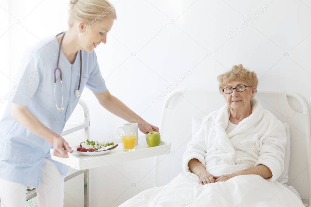 Doctor bringing food to senior