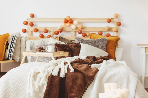 Stylish bed with decorated bedhead — Stock Photo, Image