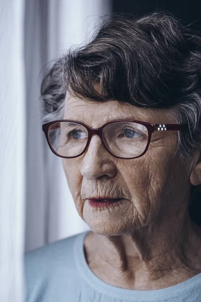 Mujer anciana solitaria con gafas — Foto de Stock