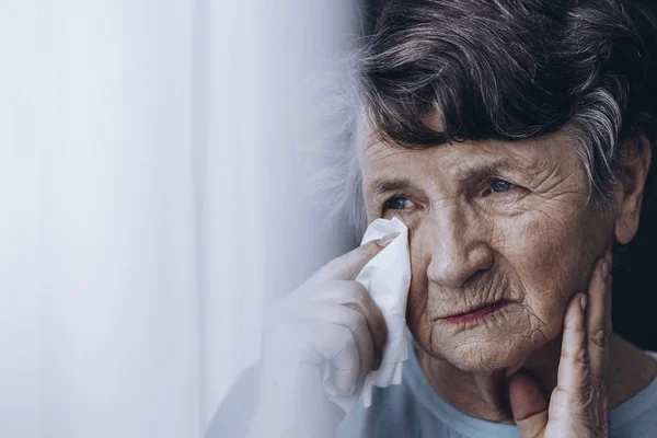Sad elderly woman wiping tears — Stock Photo, Image