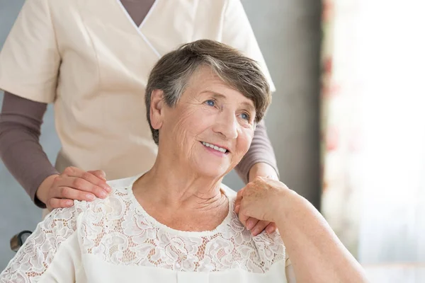 Assistente di sostegno sorridente vecchia signora — Foto Stock